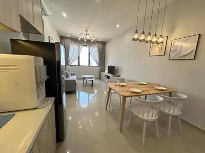 a kitchen and living room with a table and chairs at Cozy 2BR Sky Pool & Panoramic Views 1-6 Guests in Bayan Lepas