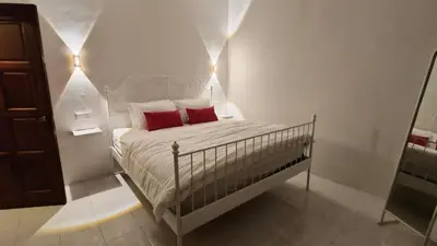 a small bedroom with a bed with two red pillows at Frangipine Villa in Tapah