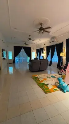 a living room with a couch and a rug on the floor at Frangipine Villa in Tapah
