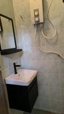 a bathroom with a sink and a mirror and a shower at Frangipine Villa in Tapah
