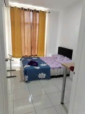 a small bedroom with a bed and a table at Al Qarni Homestay 1 in Ipoh