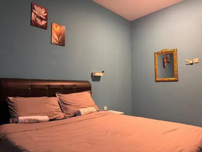 a bedroom with a bed with orange sheets and a mirror at 1br 2pax 1car only Malaysian guest only in Bayan Lepas