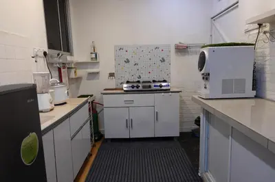 a small kitchen with white cabinets and a microwave at ManMai Homestay Mesra Solat Double Storey in Nibung Tebal