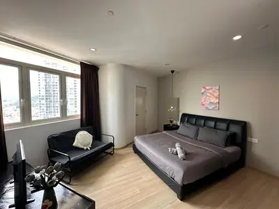 a bedroom with a large bed and a chair at Comfort 1BR studio One One Eight Island Plaza in Tanjong Tokong