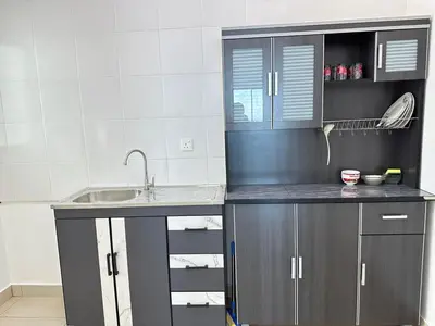 a kitchen with gray cabinets and a sink at HappySty in Bayan Lepas
