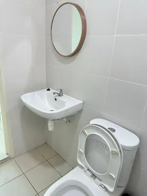 a bathroom with a toilet and a sink and a mirror at HappySty in Bayan Lepas