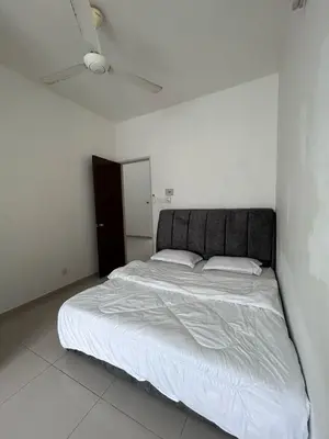 a bedroom with a large bed in a white room at Naura Homes Penang in Kampong Batu Maung