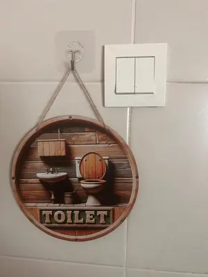 a wooden toilet sign hanging on a wall at Naura Homes Penang in Kampong Batu Maung