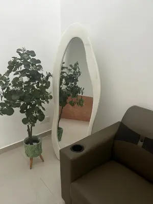 a living room with a couch and a mirror at Naura Homes Penang in Kampong Batu Maung