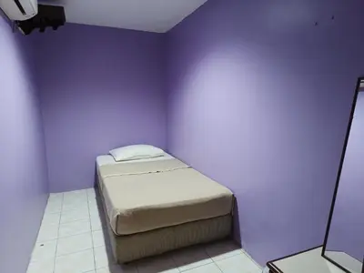 a bed in a room with a purple wall at HOTEL MEDAN KiDD in Ipoh