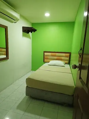 a green bedroom with a bed in a room at HOTEL MEDAN KiDD in Ipoh