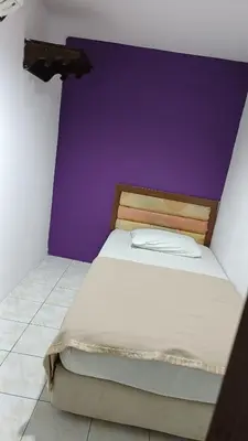 a bed in a room with a purple wall at HOTEL MEDAN KiDD in Ipoh