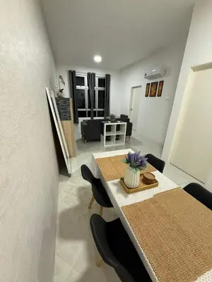 a dining table and chairs in a living room at Kyra's Downtown Delight in Ipoh