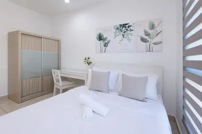 a white bedroom with a white bed and a desk at 2R2B Lovely Home 1-8pax Gurney Mansion One in George Town