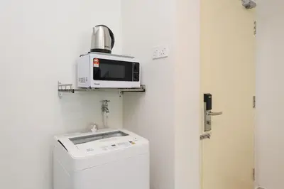 a microwave sitting on a shelf above a washing machine at 2R2B Lovely Home 1-8pax Gurney Mansion One in George Town
