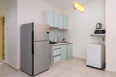 a white kitchen with a refrigerator and a sink at 2R2B Lovely Home 1-8pax Gurney Mansion One in George Town
