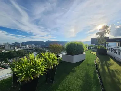 a green yard with potted plants on top of a building at Urban Suites - Family Suite in Jelutong