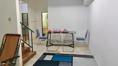 a dining room with a table and blue chairs at Homestay Hill View Lumut in Lumut