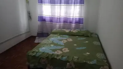 a bedroom with a bed with a green comforter at Homestay Hill View Lumut in Lumut