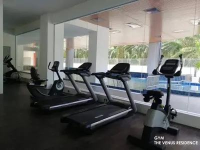 a gym with treadmills and a row of exercise bikes at Venus Home Retreat - Pool,Gym,Playground,Rooftop Garden View in Kampong Lumut Kiri