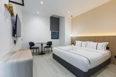 a hotel room with a bed and a table at Edenwood Hotel in George Town