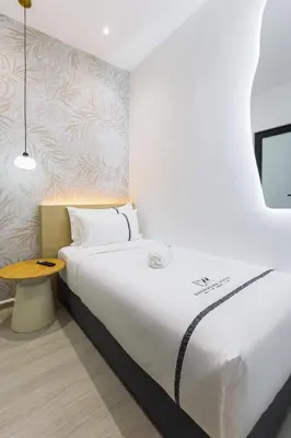 a bedroom with a large bed and a table at Edenwood Hotel in George Town