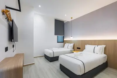 a hotel room with two beds and a flat screen tv at Edenwood Hotel in George Town
