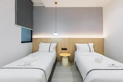 two beds in a room with a table between them at Edenwood Hotel in George Town