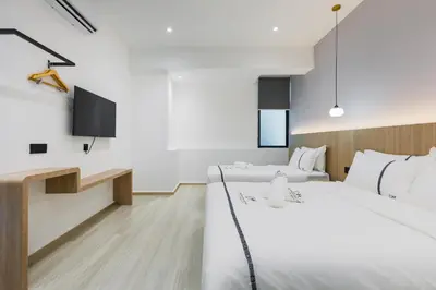 a hotel room with two beds and a tv at Edenwood Hotel in George Town