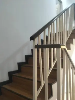 a staircase with wooden railings in a house at Tenang Tambun House in Tanjung Rambutan