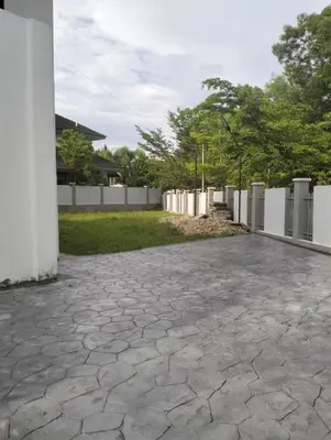 a stone driveway with a white fence and trees at Tenang Tambun House in Tanjung Rambutan