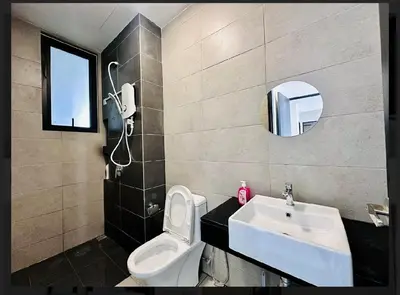 a bathroom with a toilet and a sink and a mirror at Spacious 3BR Retreat Comfort & Style in the City 2-10pax in Jelutong