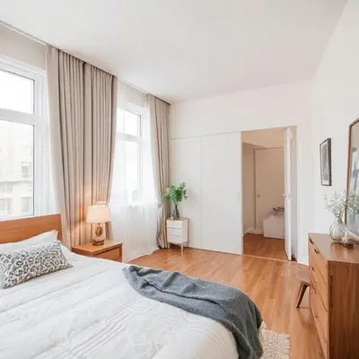 a white bedroom with a bed and a large window at Jazz Suites Penang in Tanjong Tokong