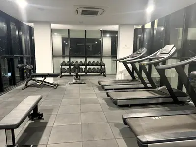 a gym with several treadmills and machines at Modern 3BR Getaway Perfect for Families & Groups 10 pax in Jelutong