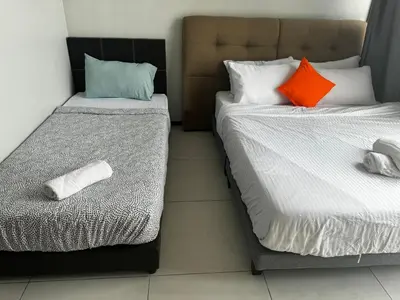 two beds sitting next to each other in a room at Cozy & Chic 3BR Apartment Great Location 2-10pax in Jelutong