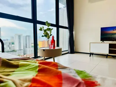 a room with a bed and a television and a vase on a table at Spacious 3BR Retreat Comfort & Convenience in Prime Location 2-10pax in Jelutong