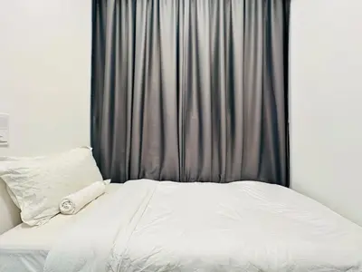 a bed with white sheets and a gray curtain at Spacious 3BR Retreat Comfort & Convenience in Prime Location 2-10pax in Jelutong