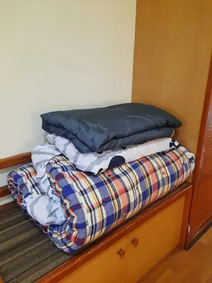 a pile of clothes sitting on top of a bed at Kea Farm Sweet Cozy Resort Copthorne in Brinchang