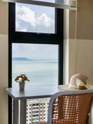 a window with a table and a hat on a table at Urban Seaview Home in George Town