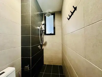a small bathroom with a shower and a window at Perfect for Groups! 2BR with 5 Queen Beds & WiFi in Jelutong