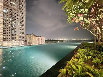 a large swimming pool in a city with tall buildings at Perfect for Groups! 2BR with 5 Queen Beds & WiFi in Jelutong