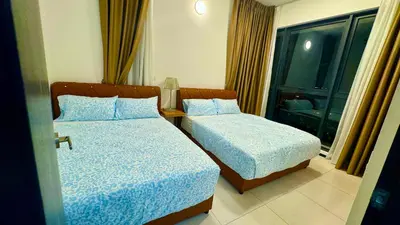 a hotel room with two beds and a window at Comfortable 2BR 5 Queen Beds, Netflix & Free Parking in Jelutong