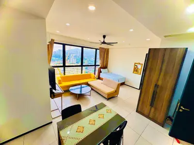 a living room with a yellow couch and a table at Comfortable 2BR 5 Queen Beds, Netflix & Free Parking in Jelutong