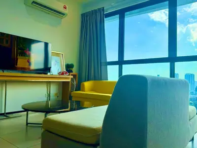 a living room with a couch and a table at Comfortable 2BR 5 Queen Beds, Netflix & Free Parking in Jelutong