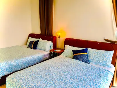 a hotel room with two beds and a lamp at Modern 2BR Home 5 Queen Beds, Near Attractions in Jelutong