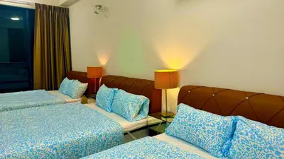 a hotel room with two beds and two lamps at Modern 2BR Home 5 Queen Beds, Near Attractions in Jelutong