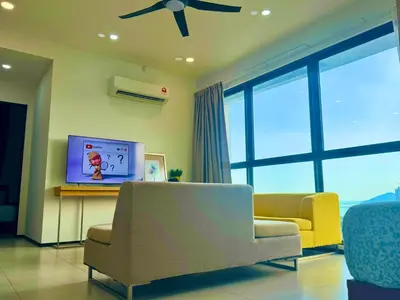 a living room with a couch and a tv at Modern 2BR Home 5 Queen Beds, Near Attractions in Jelutong