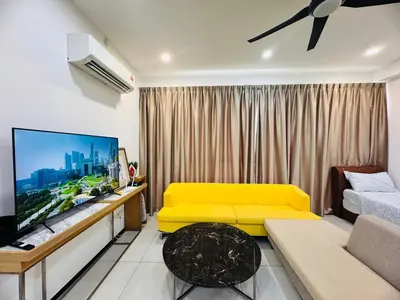 a living room with a yellow couch and a tv at Modern 2BR Home 5 Queen Beds, Near Attractions in Jelutong