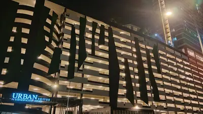 a large building with a sign on it at night at Relax & Unwind 2BR Apartment with 5 Queen Beds in Jelutong