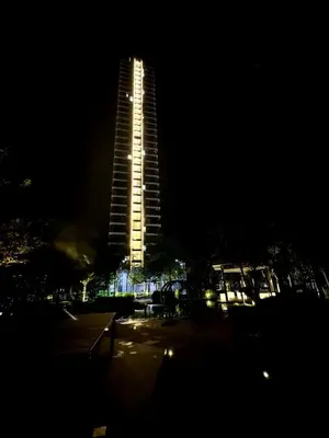 a tall building is lit up at night at Relax & Unwind 2BR Apartment with 5 Queen Beds in Jelutong